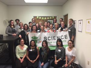 Massachusetts instructors holding a Science from Scientists banner at all staff training.