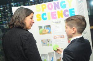 Adult speaks to student about Spongy Science experiment.