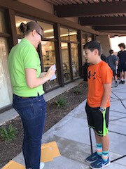 Scientist explaining an activity to a student while standing outside.