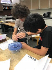 Two students working at a table.