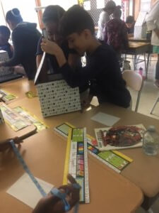 Student looks in a box as part of the observation challenge.