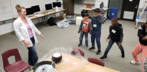 Students watch as instructor creates a dry ice bubble.