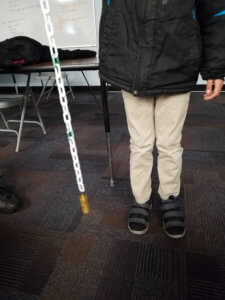 A student holds a chain with weights on the end.