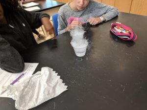 Students watch water and dry ice in cups.