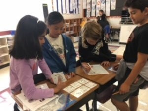 Students working at a table organizing cards.