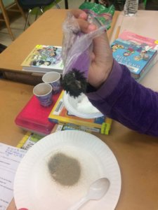 Students use a magnet to remove iron fillings from a mixture.