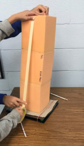 Students use tape to connect foam blocks on at shake table.