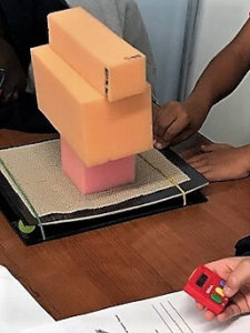 Students stack foam blocks on a shake table.