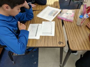 Student looks at a table on his worksheet.