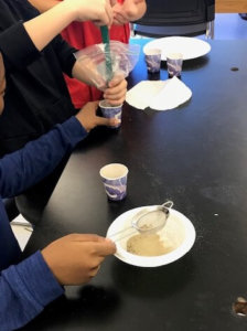 Students use a magnet and a strainer to separate a mixture.