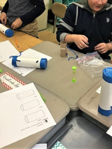 Students make a model of a mystery to be using a paper towel roll