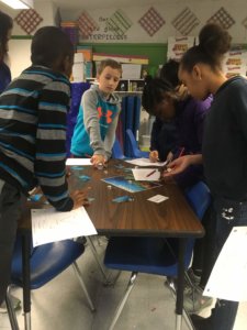 Students roll dice for the water cycle game.