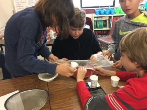 Students use cheesecloth to separate a mixture.