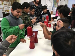 Students use a string tool to stack solo cups.