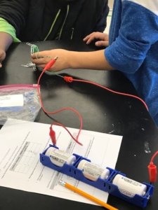 Students test 3 batteries in their electromagnet circuit.