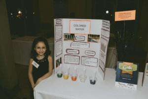 A student shows her science fair project at the STEM gala.