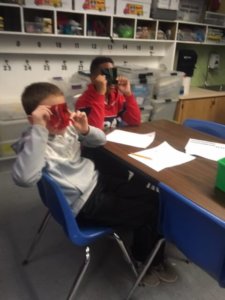 Students look through red and green color filters.